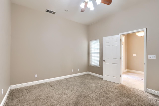 empty room with ceiling fan, baseboards, visible vents, and light carpet