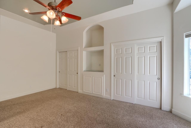 unfurnished bedroom with baseboards, multiple windows, and carpet