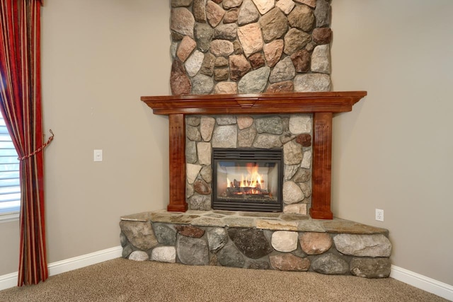 room details featuring a stone fireplace, baseboards, and carpet floors