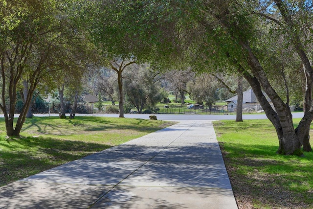 view of property's community featuring a yard and fence