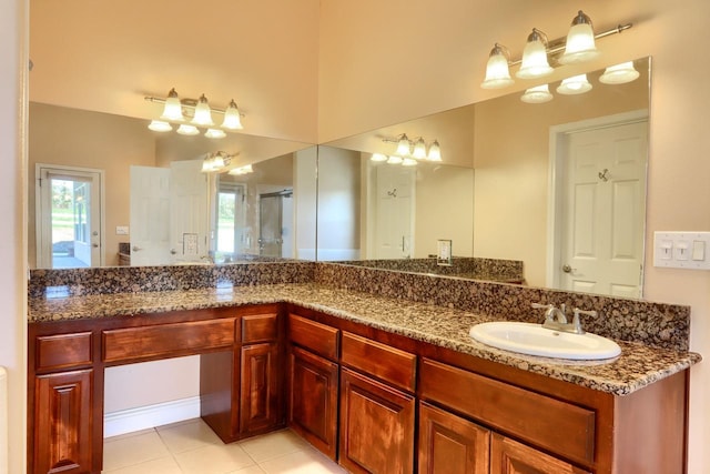 full bath featuring a wealth of natural light, tile patterned flooring, vanity, and an enclosed shower