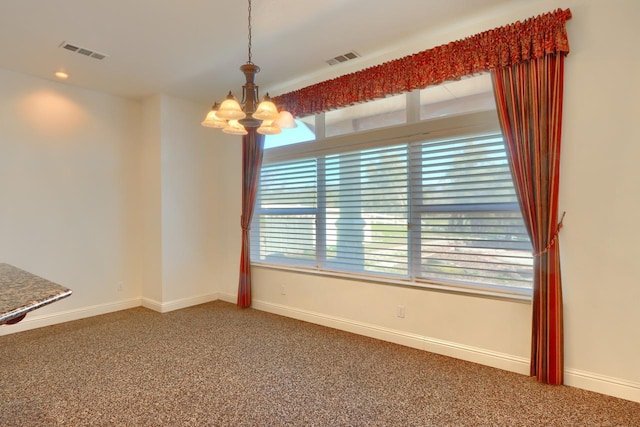 spare room featuring visible vents, baseboards, a chandelier, and carpet flooring