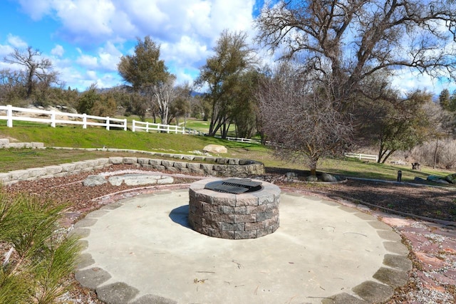 view of patio featuring fence and a fire pit