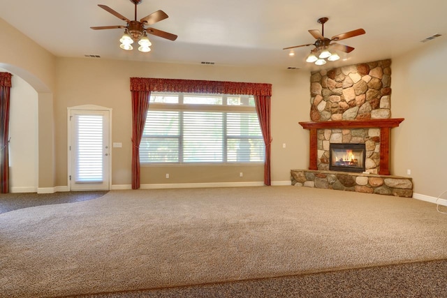 unfurnished living room with visible vents, carpet flooring, a fireplace, and ceiling fan