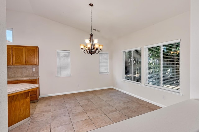 unfurnished dining area featuring baseboards, visible vents, an inviting chandelier, lofted ceiling, and light tile patterned flooring