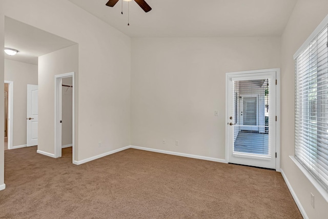 carpeted spare room with baseboards and ceiling fan