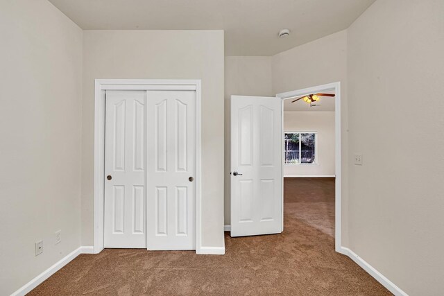 unfurnished bedroom with a closet, baseboards, and carpet