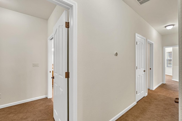 hall featuring baseboards and carpet floors