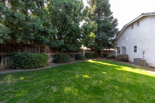 view of yard featuring central AC unit and fence