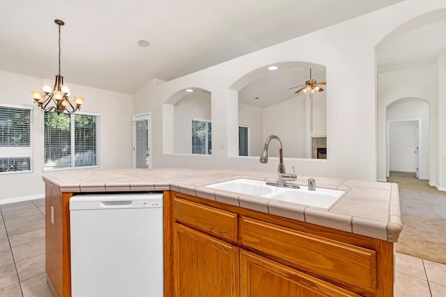 kitchen with dishwasher, vaulted ceiling, light tile patterned floors, light carpet, and a sink