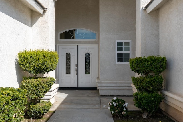 doorway to property featuring stucco siding