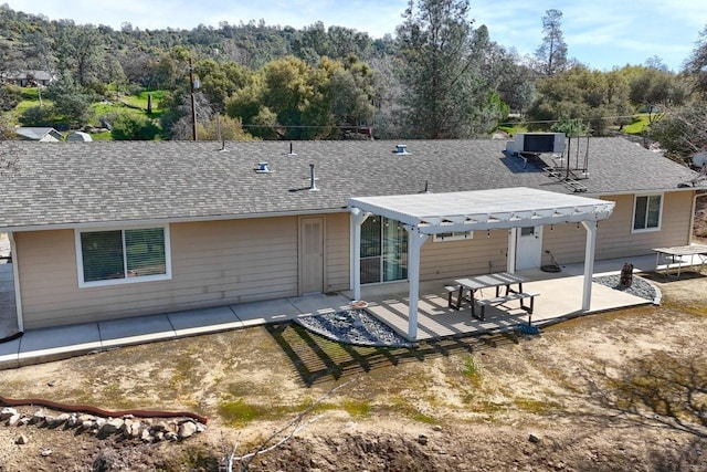 29878 Deer Trail Ln, Coarsegold, CA 93614 - rear view of house featuring roof with shingles, a pergola, a wooded view, cooling unit, and a patio area