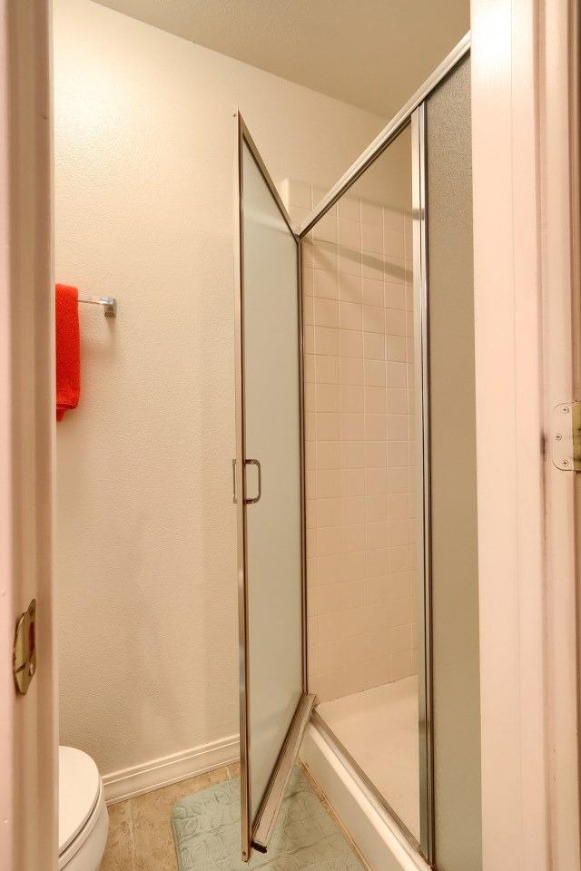 29878 Deer Trail Ln, Coarsegold, CA 93614 - full bathroom with toilet, tile patterned flooring, baseboards, and a stall shower