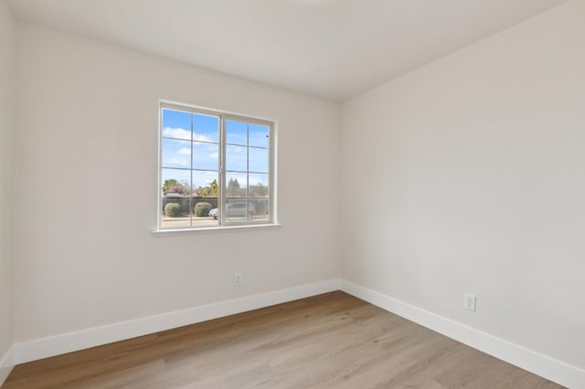 unfurnished room with light wood-style flooring and baseboards