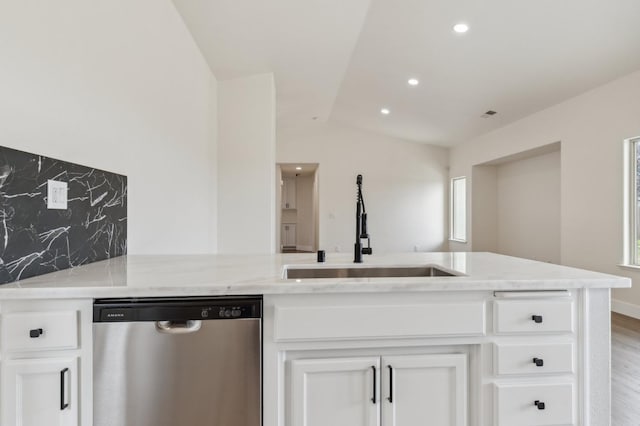 kitchen featuring a sink, light stone counters, white cabinetry, decorative backsplash, and dishwasher