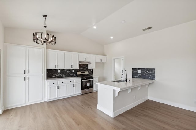 819 Hill Ave, Fowler, CA 93625 - kitchen featuring gas stove, a sink, a peninsula, white cabinetry, and a chandelier