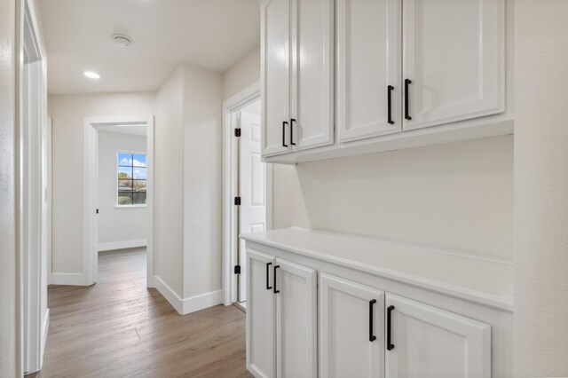 corridor with recessed lighting, baseboards, and light wood-style flooring