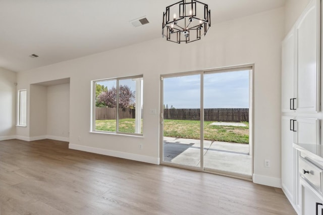 interior space with visible vents, baseboards, an inviting chandelier, and light wood-style flooring