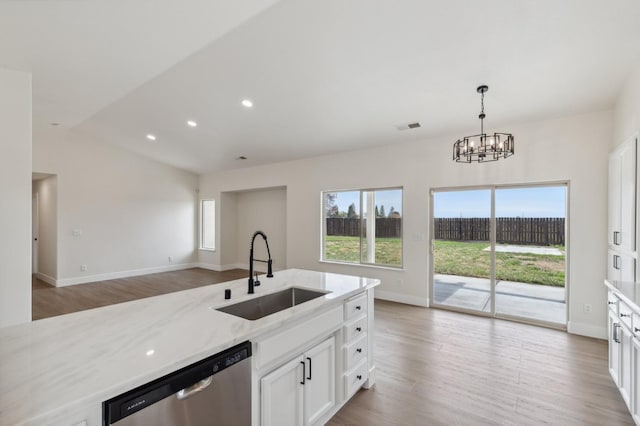 kitchen featuring visible vents, a sink, plenty of natural light, stainless steel dishwasher, and light stone countertops