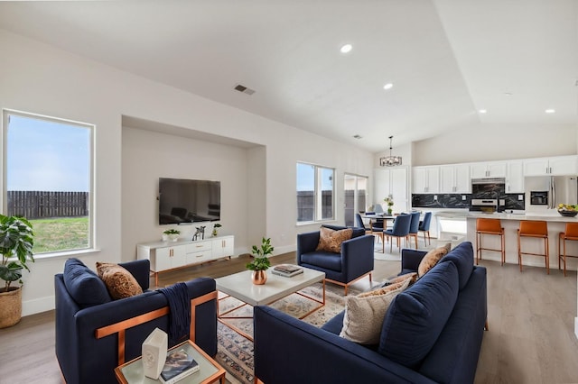 819 Hill Ave, Fowler, CA 93625 - living room with vaulted ceiling, healthy amount of natural light, light wood-style floors, baseboards, and recessed lighting