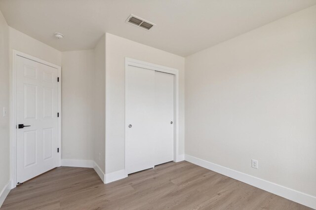 819 Hill Ave, Fowler, CA 93625 - unfurnished bedroom with baseboards, light wood-type flooring, and a closet