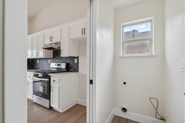 819 Hill Ave, Fowler, CA 93625 - kitchen with stainless steel range with gas stovetop, under cabinet range hood, light wood-style floors, backsplash, and white cabinetry