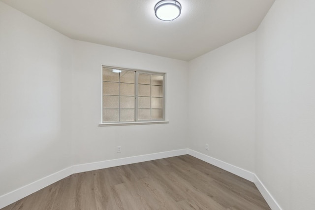 unfurnished room with baseboards and wood finished floors