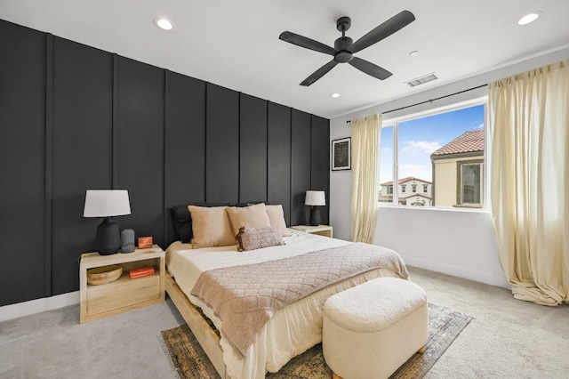 bedroom featuring a decorative wall, recessed lighting, and light carpet