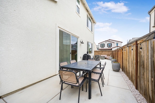 view of patio / terrace with grilling area, outdoor dining space, and a fenced backyard