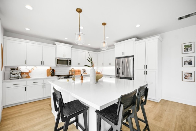 kitchen featuring visible vents, white cabinets, appliances with stainless steel finishes, and light countertops