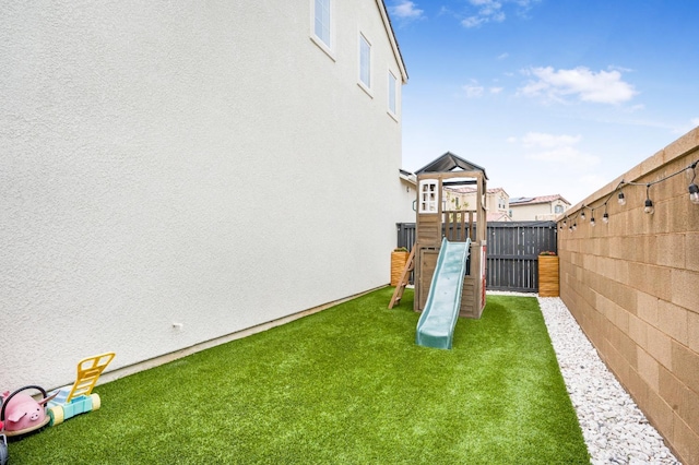 view of yard with a playground and a fenced backyard