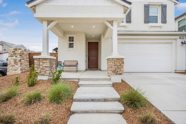 view of front of home featuring a porch, stucco siding, an attached garage, and concrete driveway