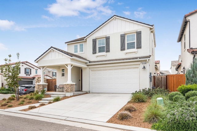 craftsman-style home featuring board and batten siding, fence, a porch, a garage, and driveway