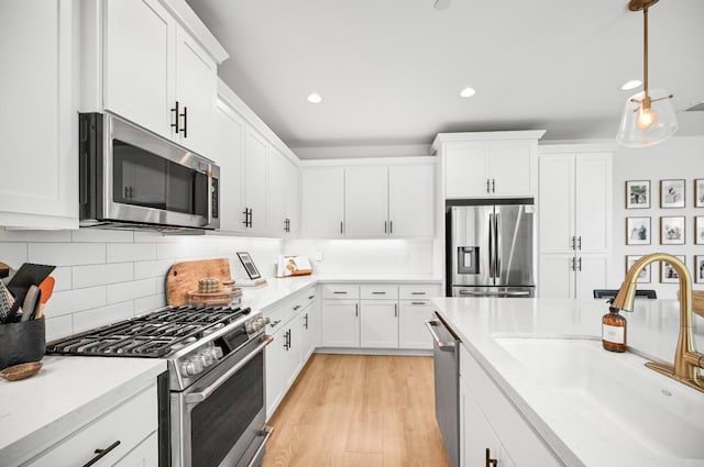 kitchen with a sink, appliances with stainless steel finishes, and white cabinetry