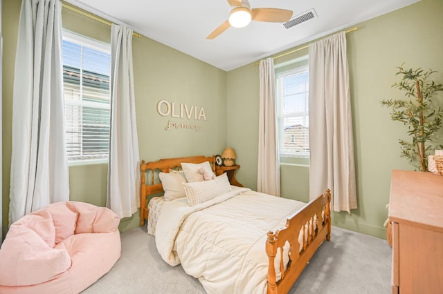 bedroom featuring a ceiling fan, light colored carpet, and visible vents