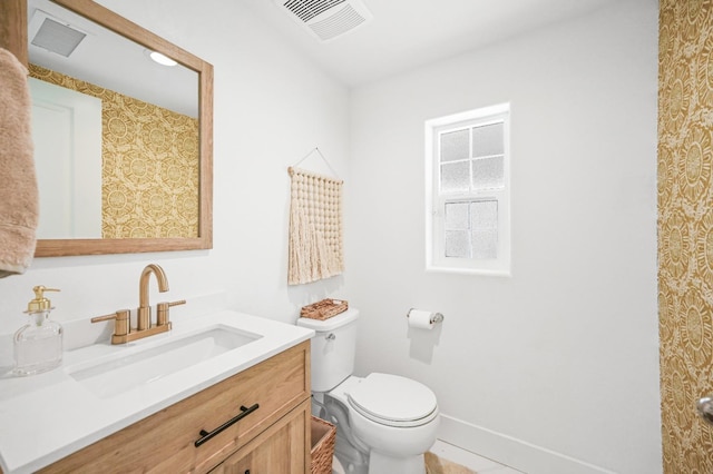 bathroom with visible vents, toilet, vanity, and baseboards