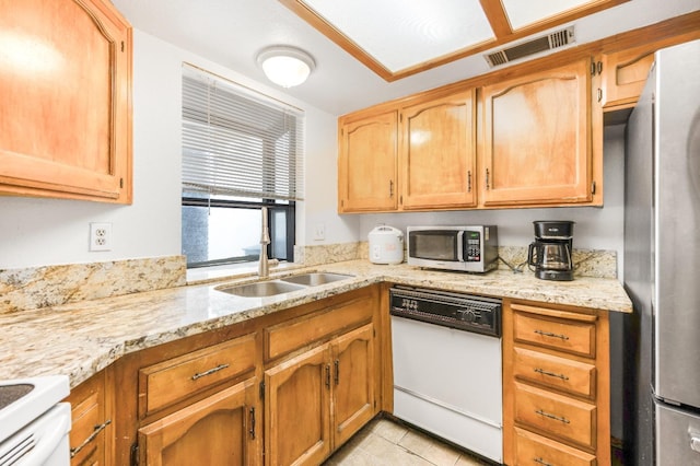 kitchen featuring visible vents, a sink, light stone counters, appliances with stainless steel finishes, and light tile patterned floors