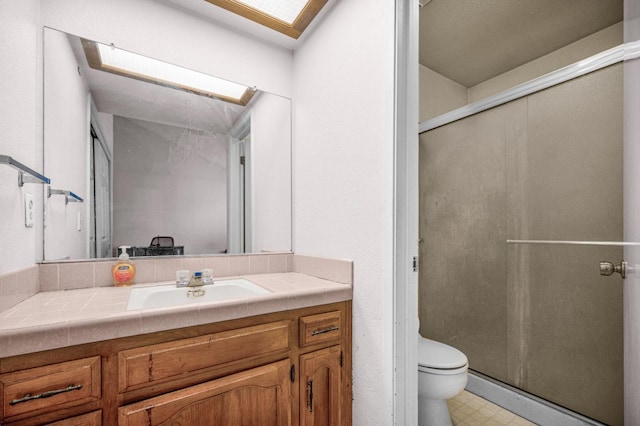 3622 W Terrace Ave, Fresno, CA 93722 - full bathroom with vanity, toilet, a stall shower, tile patterned floors, and a skylight