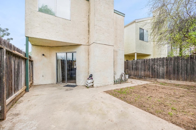 back of property with a patio, fence, and stucco siding