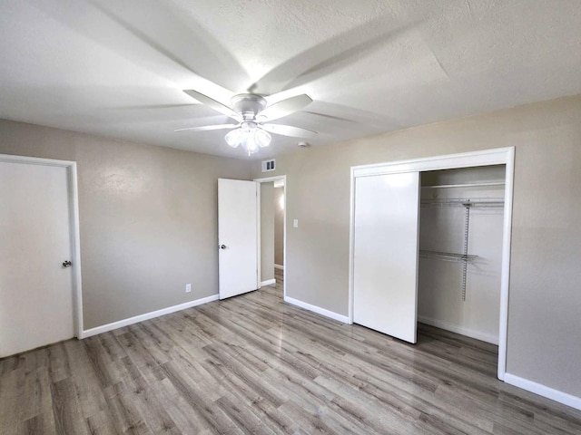 unfurnished bedroom with wood finished floors, visible vents, and baseboards