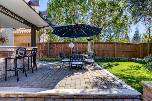 view of patio with outdoor dining area, outdoor dry bar, and fence