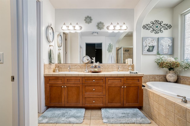 full bathroom with a sink, a shower stall, tile patterned floors, a bath, and backsplash