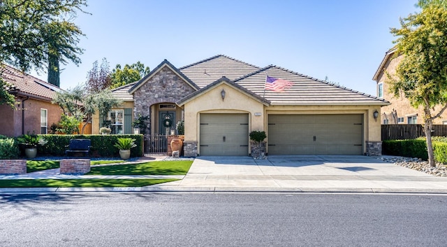 view of front of property featuring fence, a tiled roof, concrete driveway, stone siding, and an attached garage