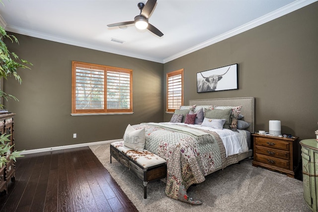 bedroom featuring visible vents, ornamental molding, a ceiling fan, hardwood / wood-style floors, and baseboards