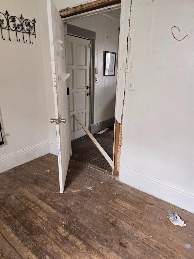 hallway with baseboards and hardwood / wood-style floors