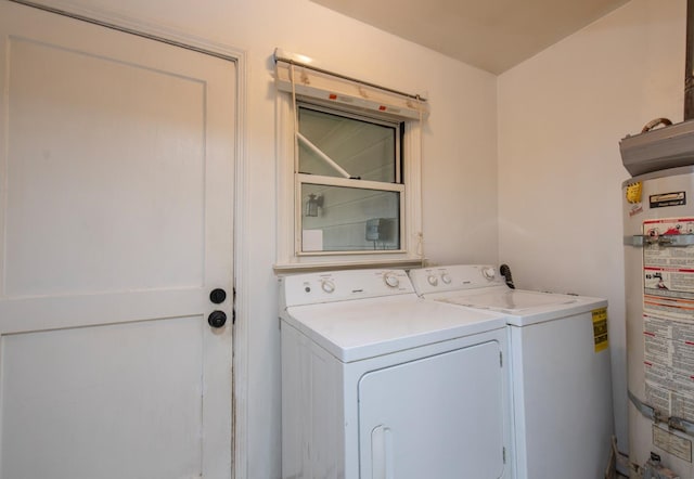 clothes washing area featuring gas water heater, washing machine and clothes dryer, and laundry area