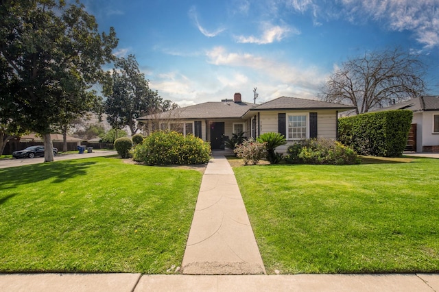 view of front of house with a chimney and a front lawn