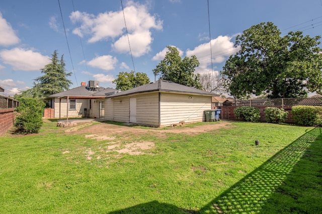 back of property featuring a fenced backyard and a yard