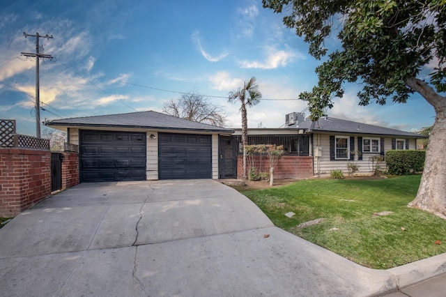 ranch-style home with brick siding, an attached garage, fence, a front yard, and driveway