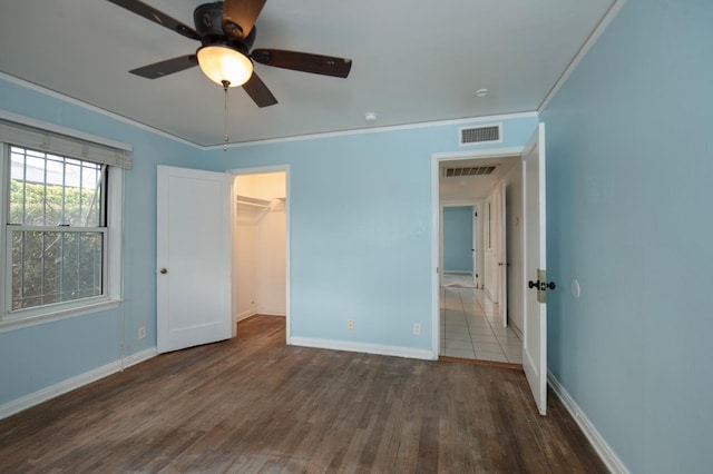 unfurnished bedroom featuring visible vents, wood finished floors, and ornamental molding